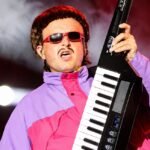 Oliver Tree Helicopter Accident tribute image showing the musician performing on stage with memorial-themed background