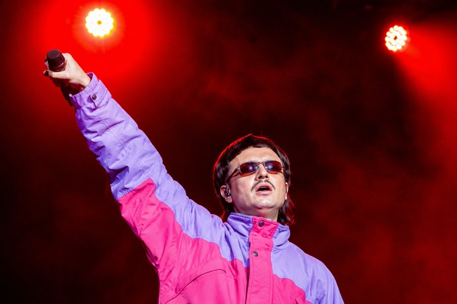 Oliver Tree Helicopter Accident tribute image showing the musician performing on stage with memorial-themed background